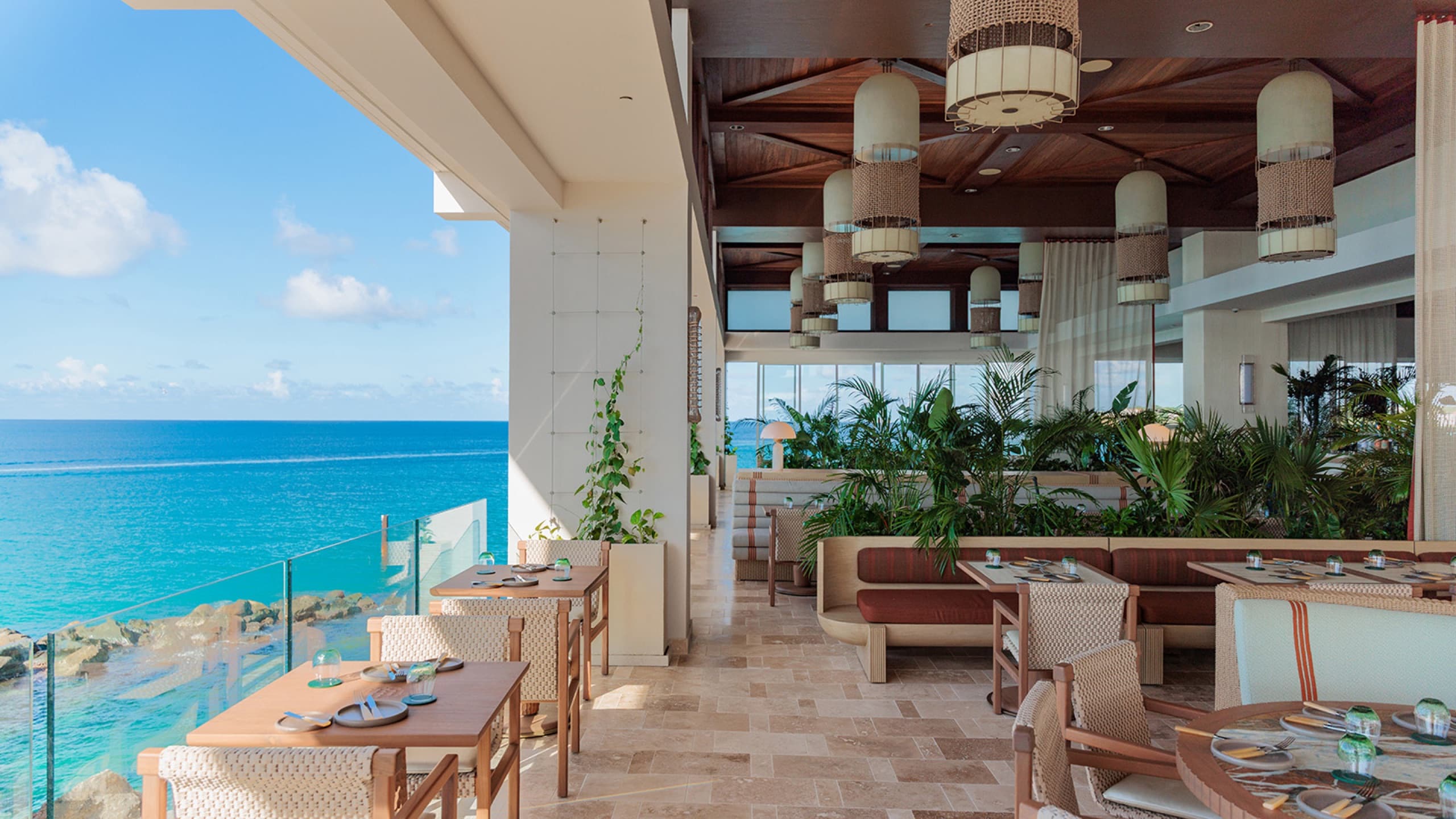 SALT restaurant terrace: tables, woven pendant lights, planting and the sea