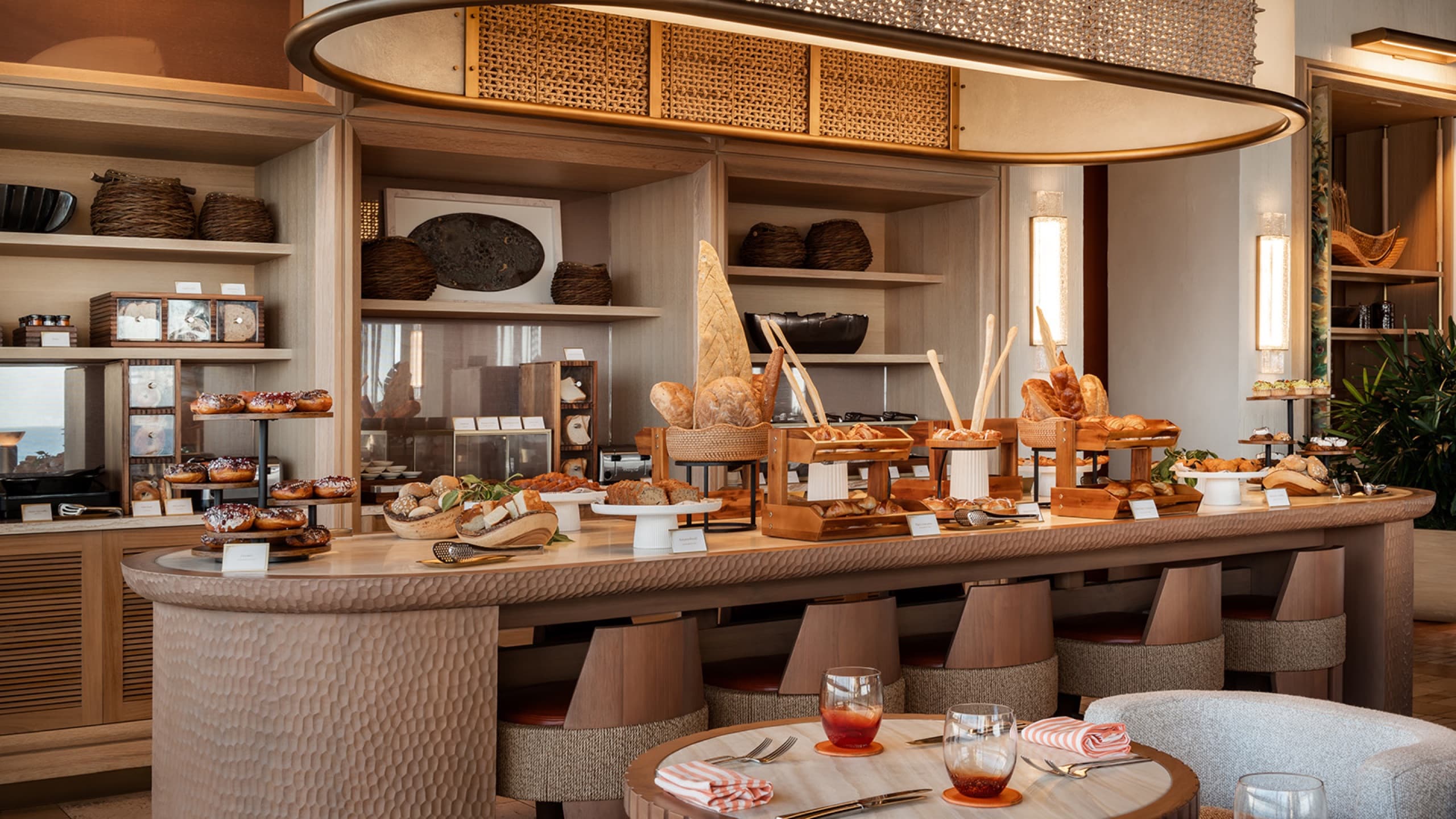 Breakfast counter with breads and pastries, hammered-wood bar and stools