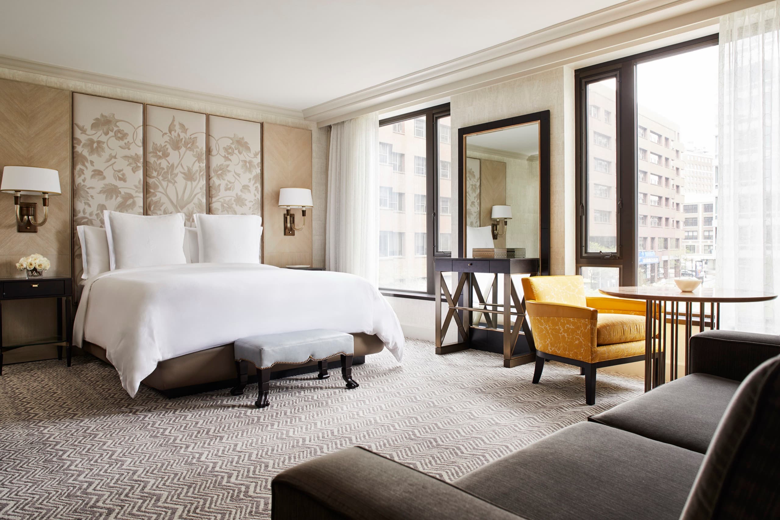 Premier King / Deluxe Garden-View Room — floral headboard, yellow velvet chairs at the window