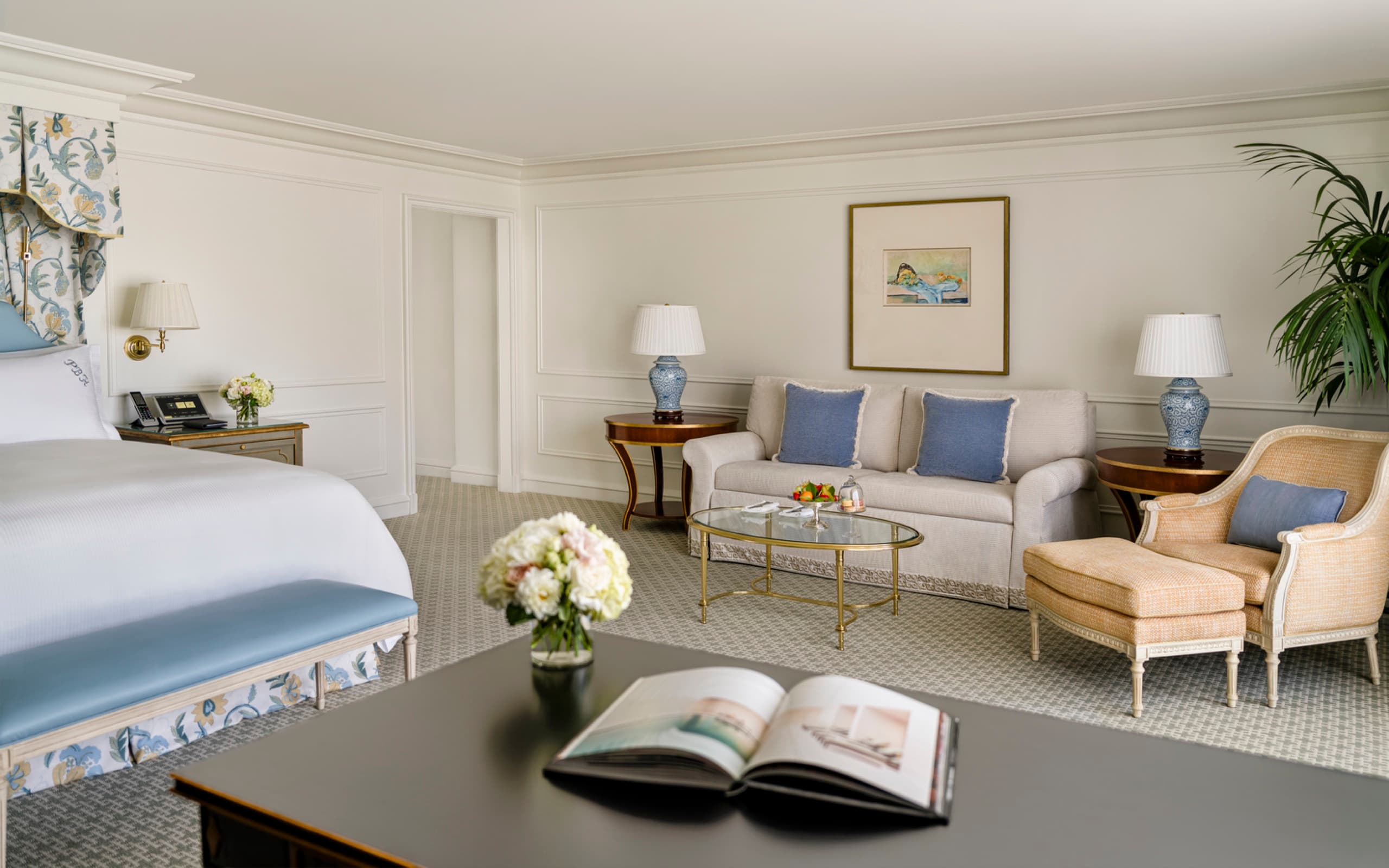 Grand Deluxe Room - king bed with floral canopy, sofa with powder-blue cushions and Bergere lounge chair (2025 HBA redesign)