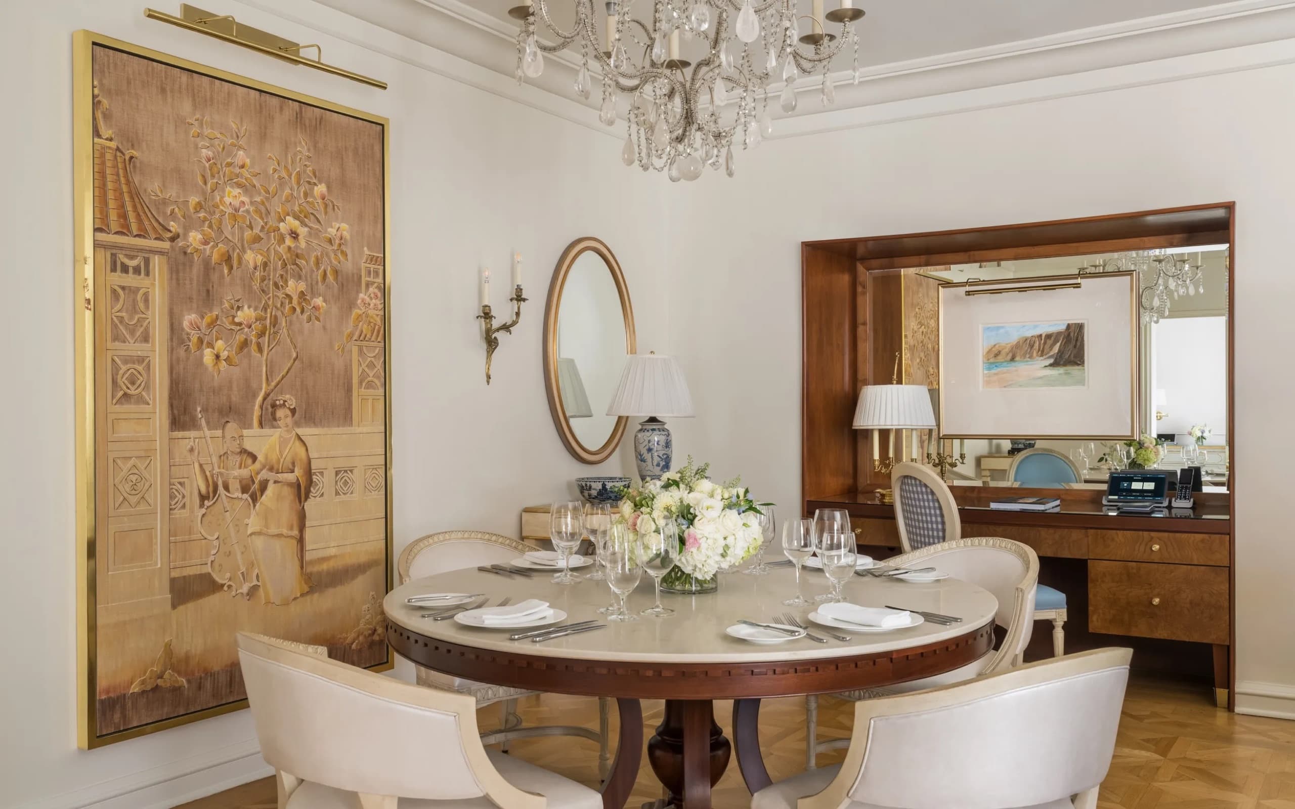Suite living room with dining table and French doors onto a balcony over the Beverly Hills hillside (2026 photography)