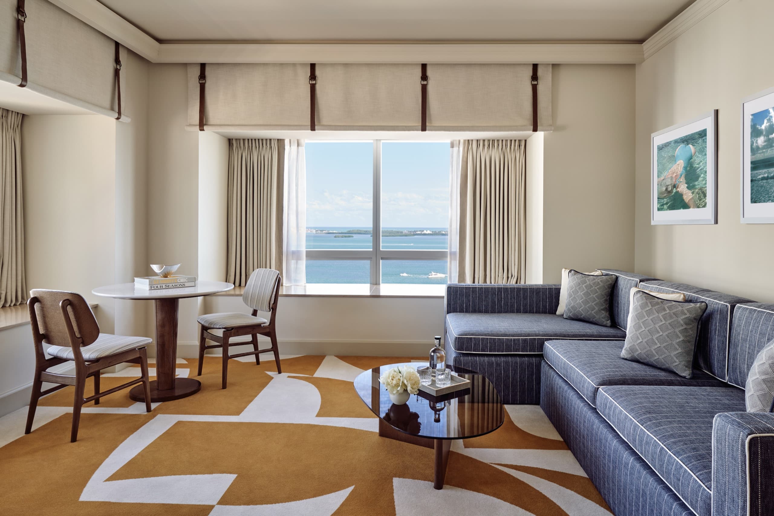 Bay-view suite living area — sofa and dining table over Biscayne Bay