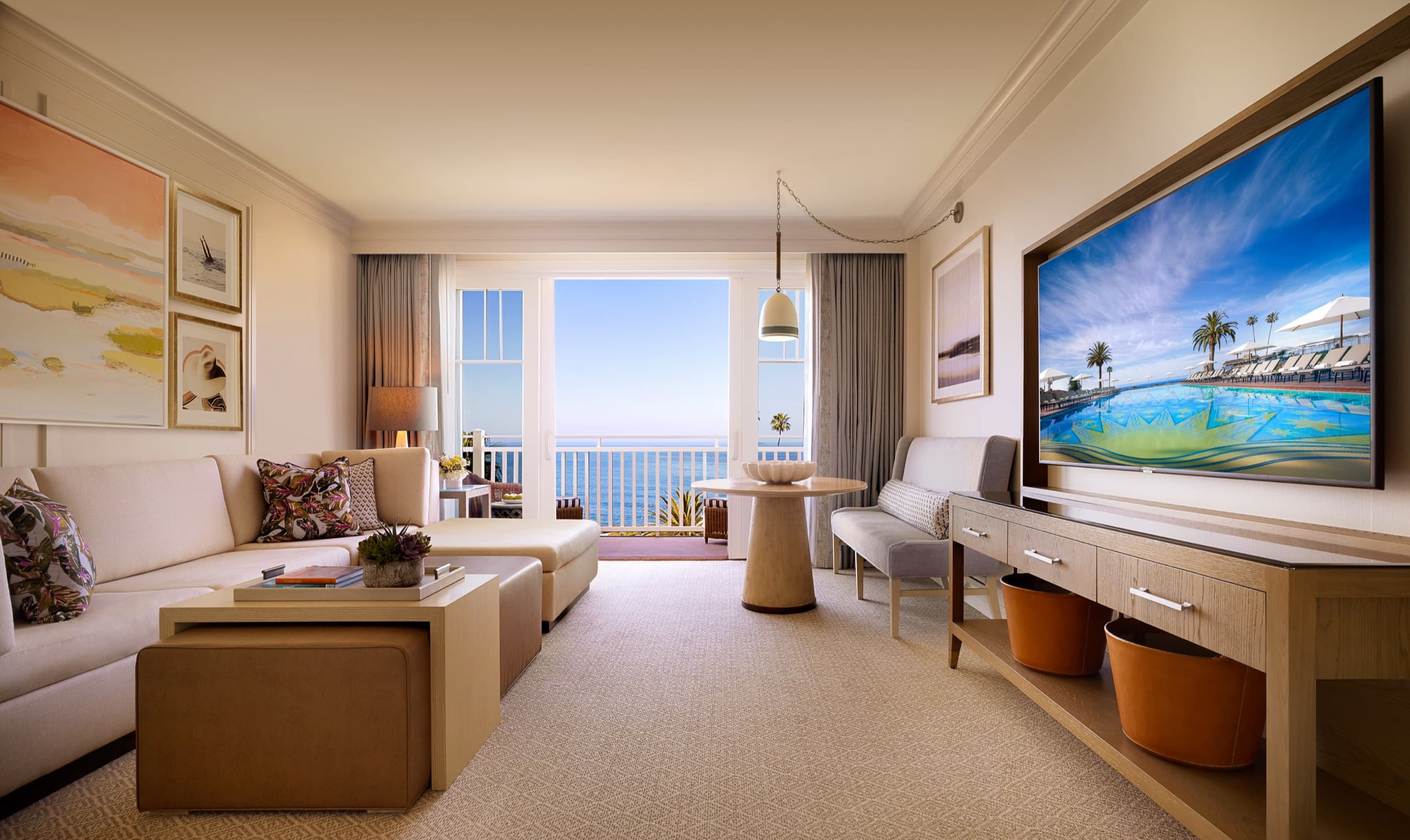 One Bedroom Ocean View King Suite — separate living room with sofa and ocean balcony (Surf palette)