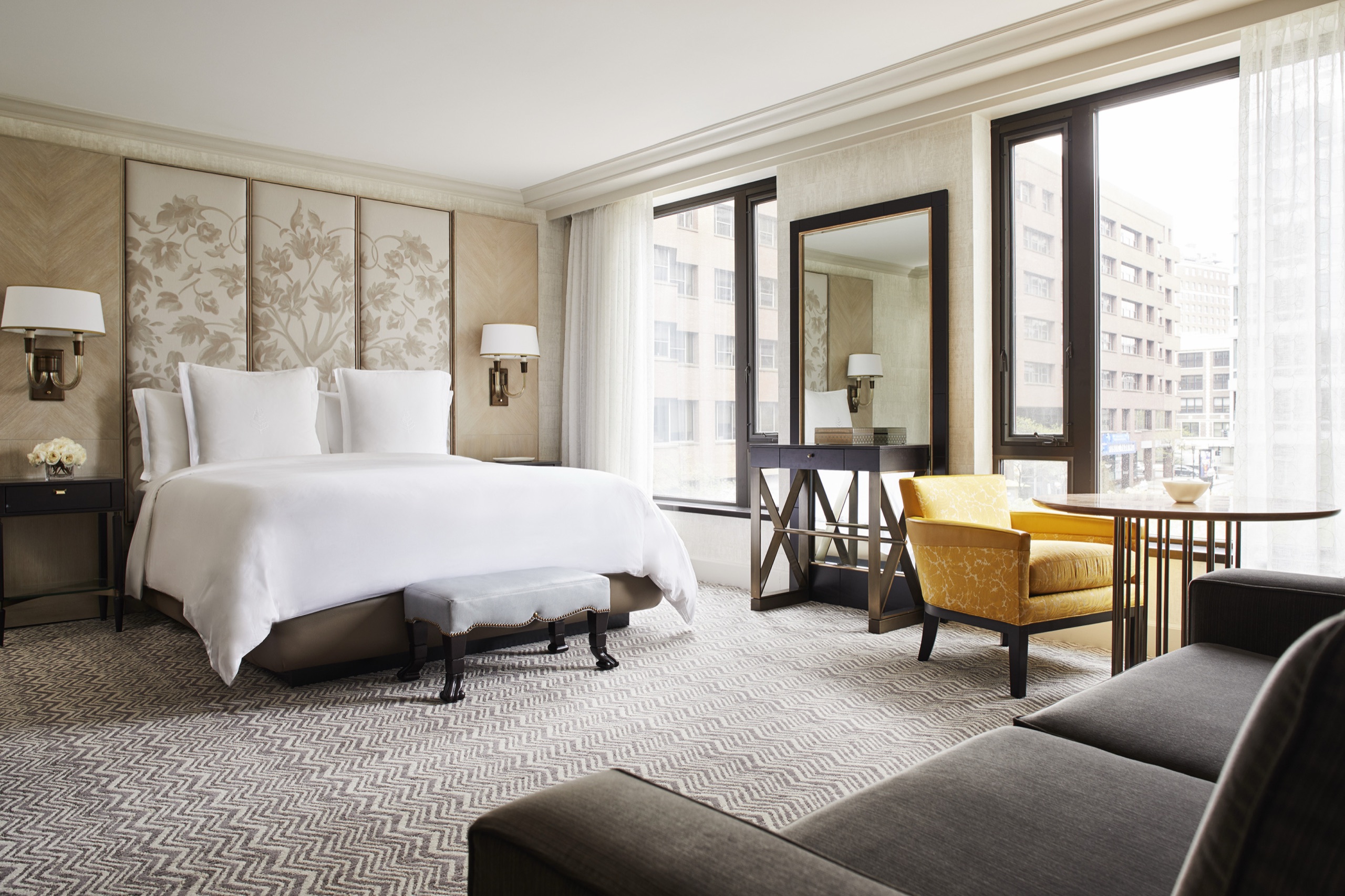 Premier King / Deluxe Garden-View Room — floral headboard, yellow velvet chairs at the window