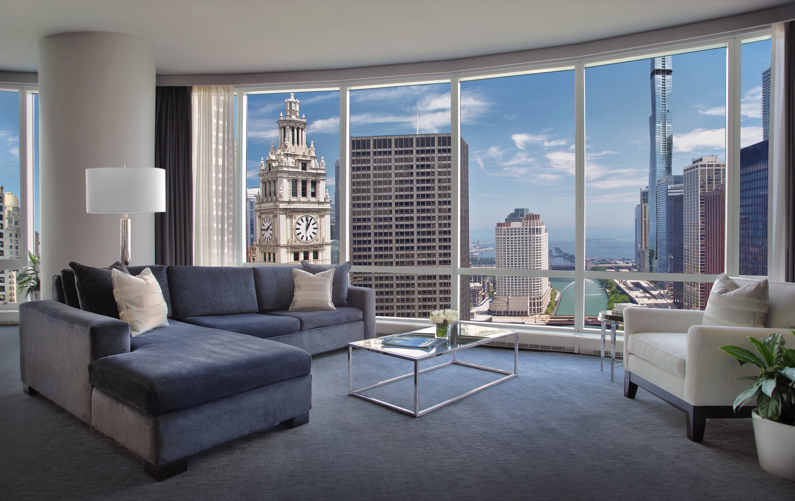 Grand Deluxe Suite living room, curved glass wall over the river and Wrigley clock tower