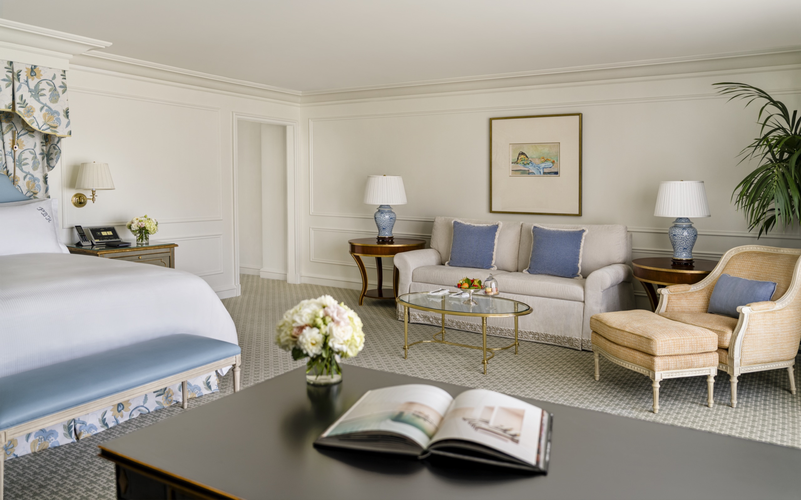 Grand Deluxe Room - king bed with floral canopy, sofa with powder-blue cushions and Bergere lounge chair (2025 HBA redesign)