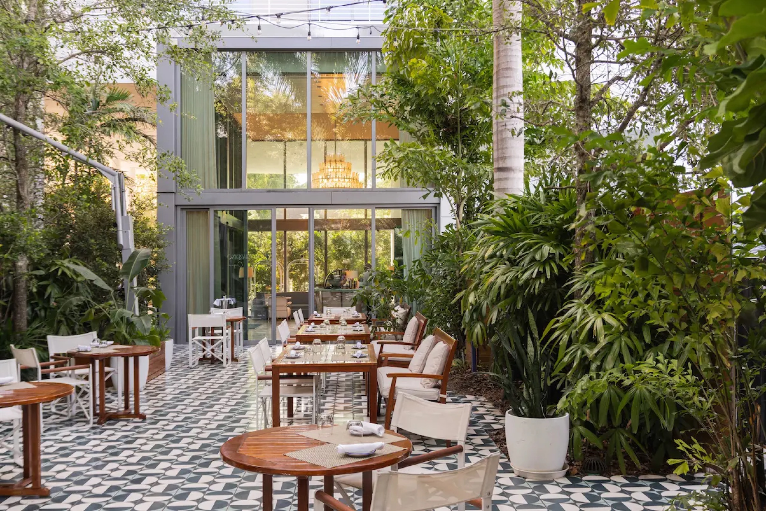 Il Giardino: garden restaurant under palms with patterned tile floor and string lights
