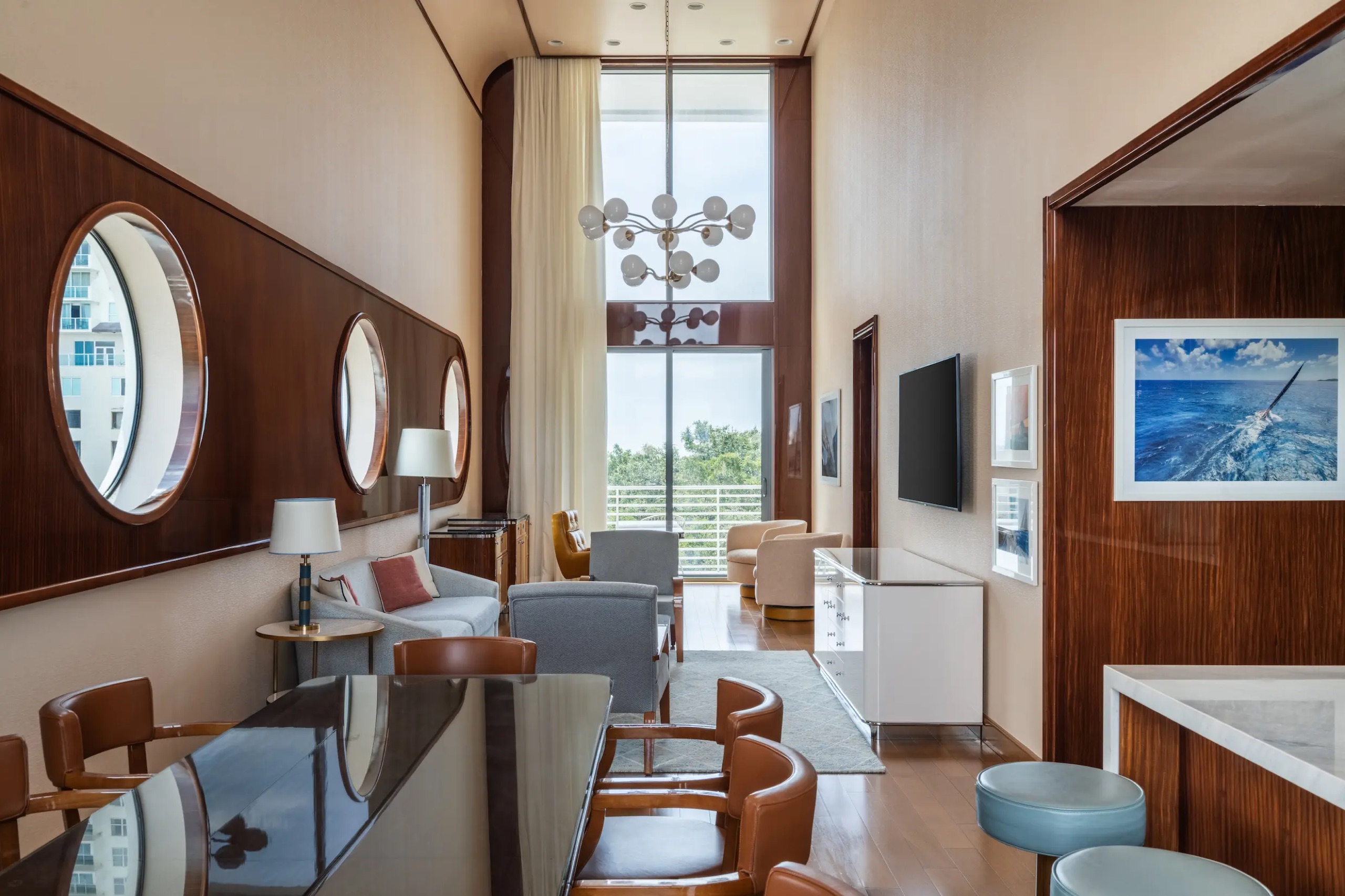 Presidential Suite: double-height living and dining room with porthole windows and timber walls