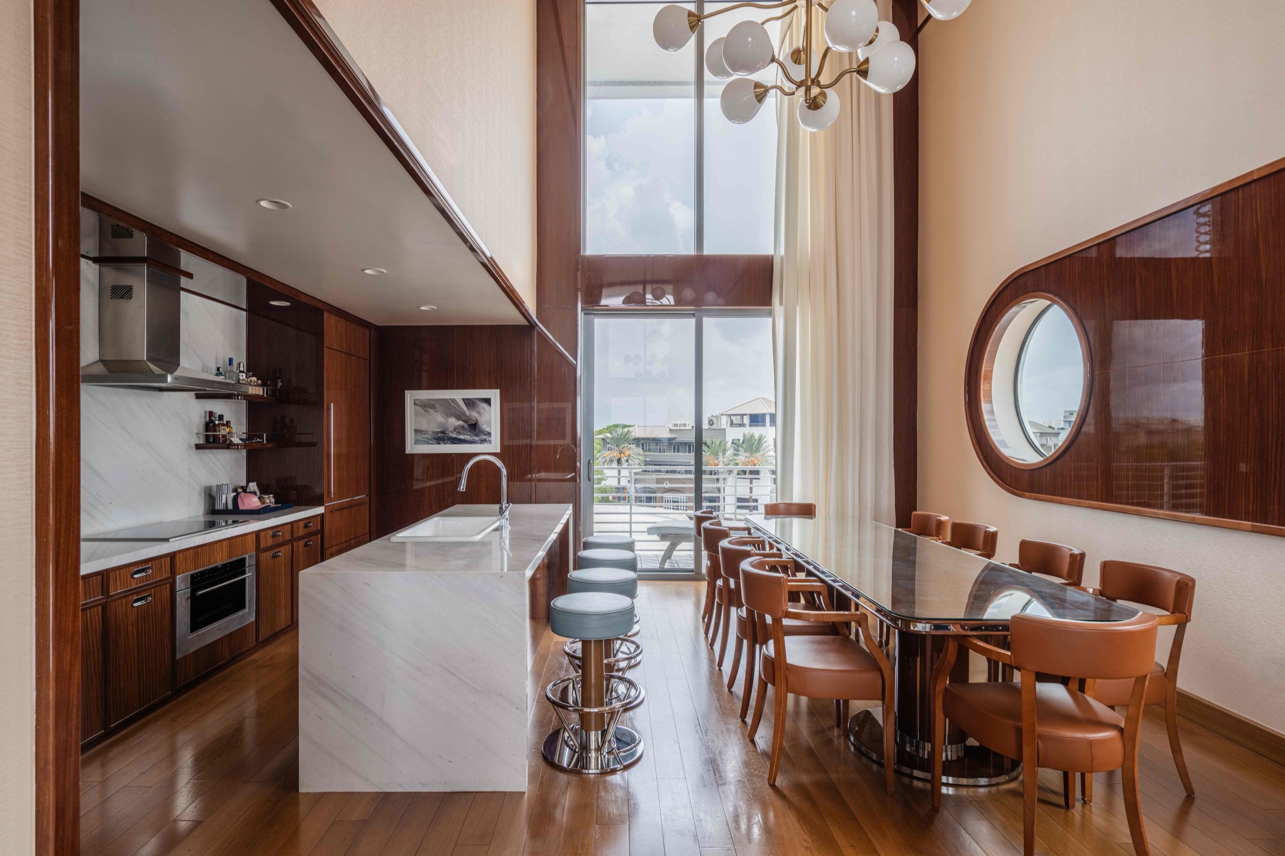 Presidential Suite dining area and marble-island kitchen with double-height glazing