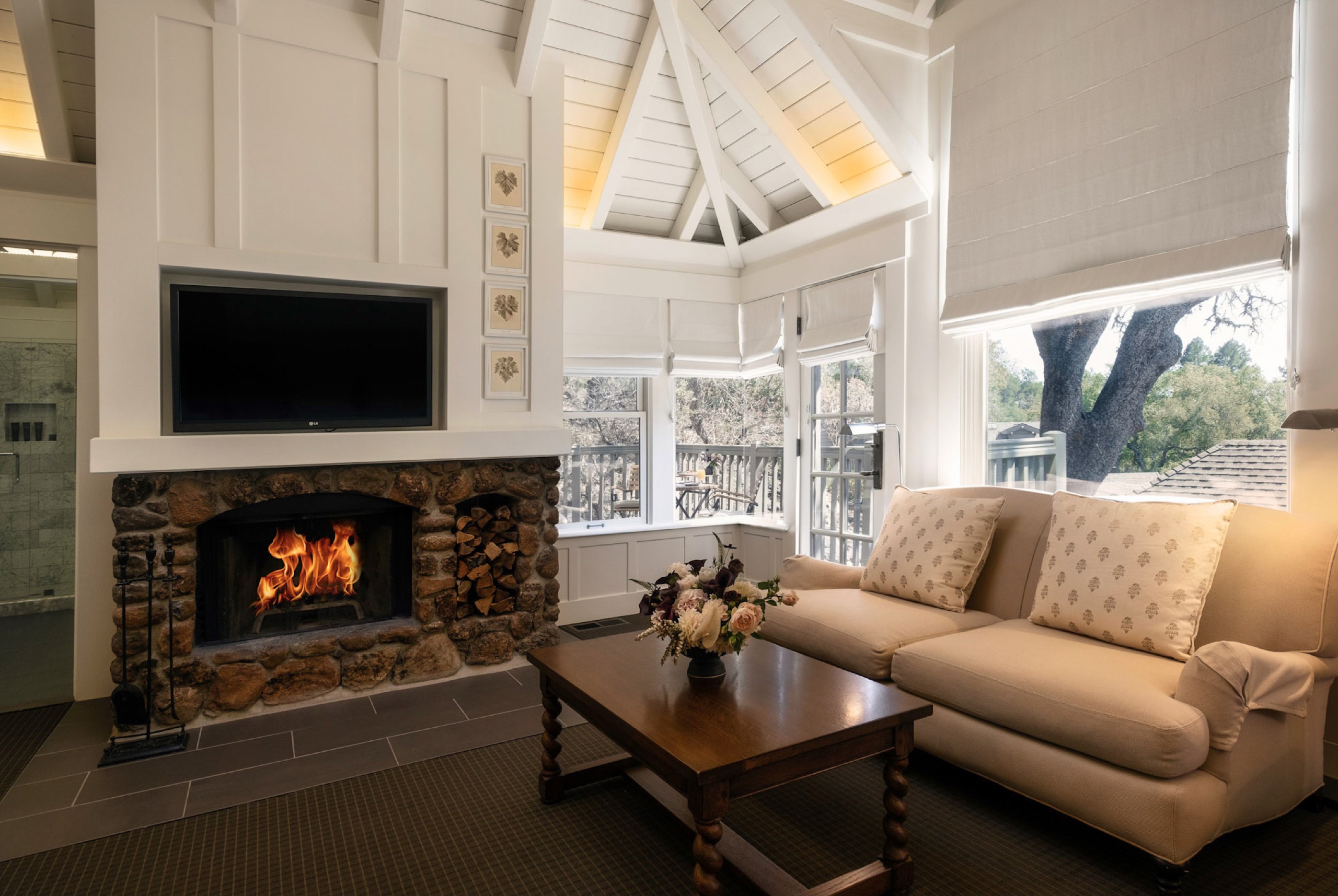 Cottage Room with bed, stone fireplace and doors to private patio