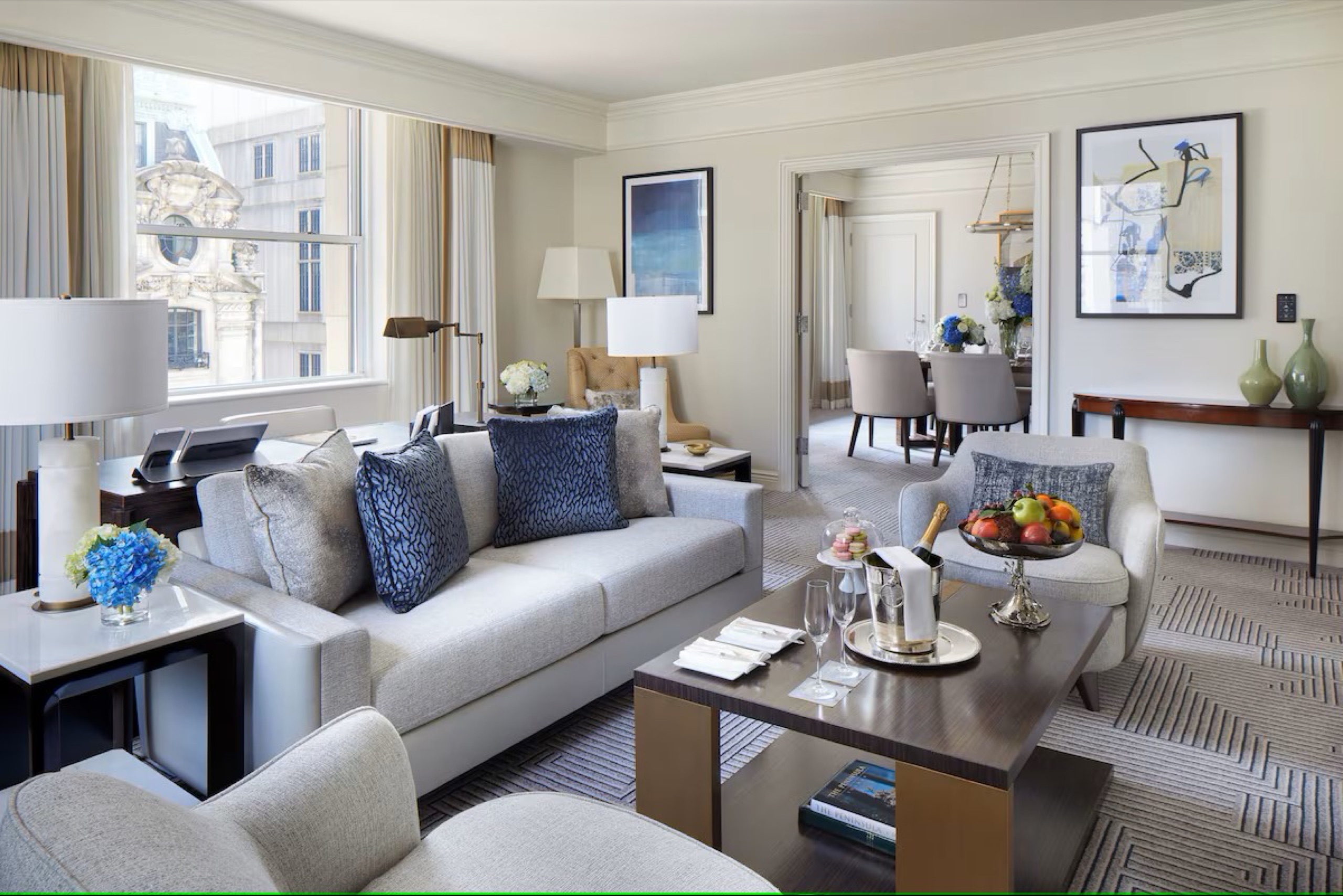 Refurbished suite living room - soft grey and blue palette, Fifth Avenue windows (2024 Bill Rooney Studio redesign)