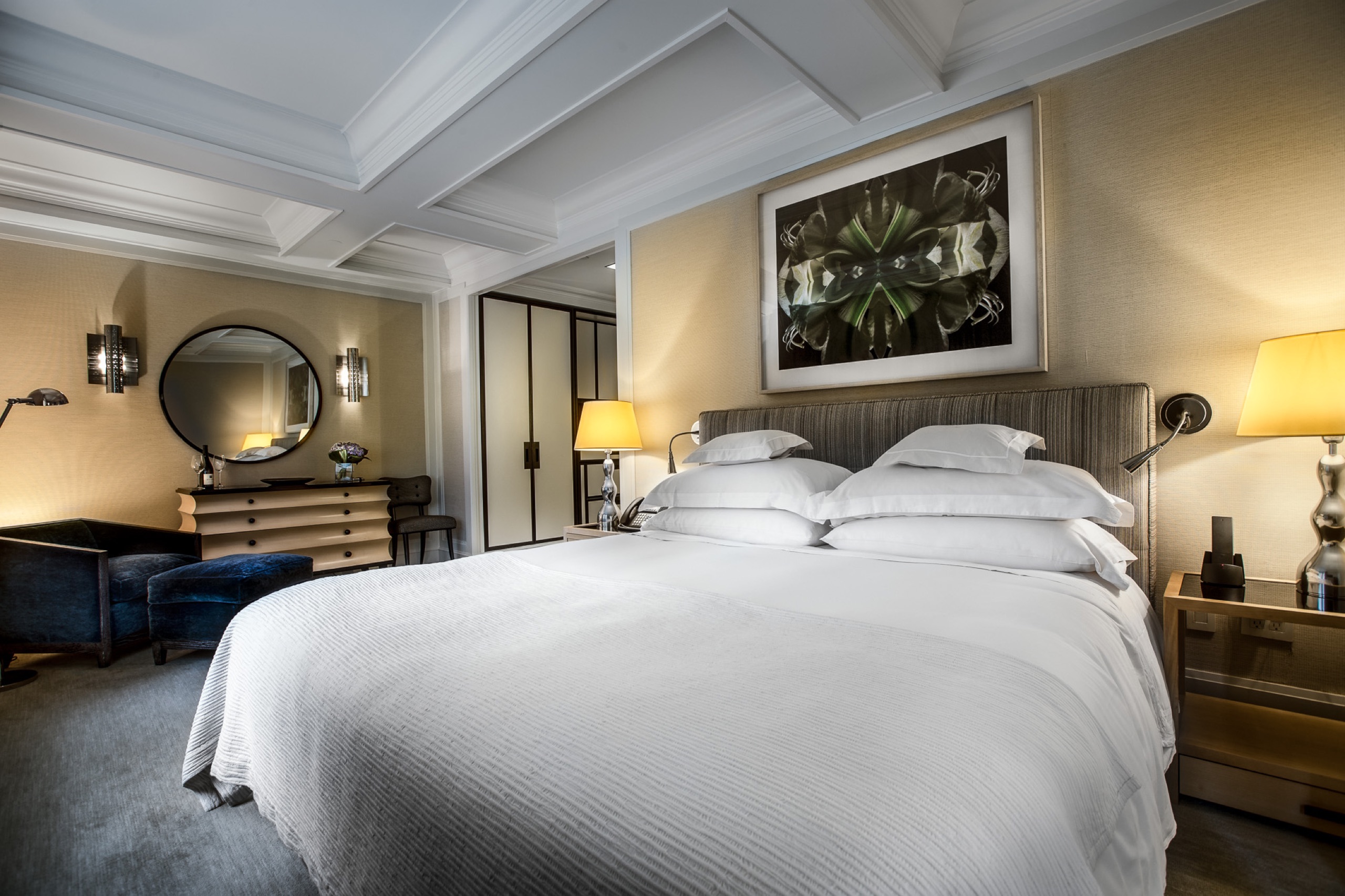 Madison Suite bedroom with round mirror and velvet bench