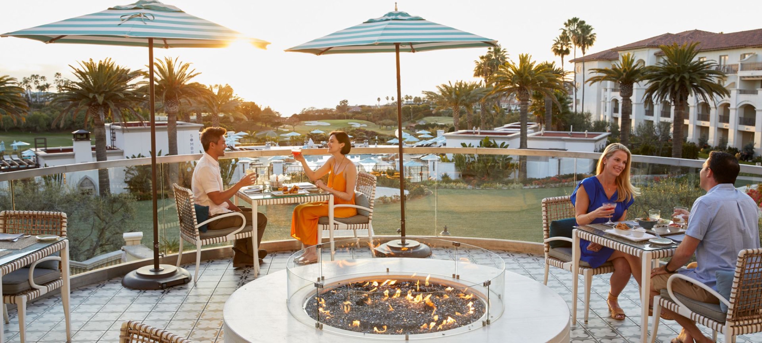 AVEO Table + Bar - terrace dining with fire pit at sunset