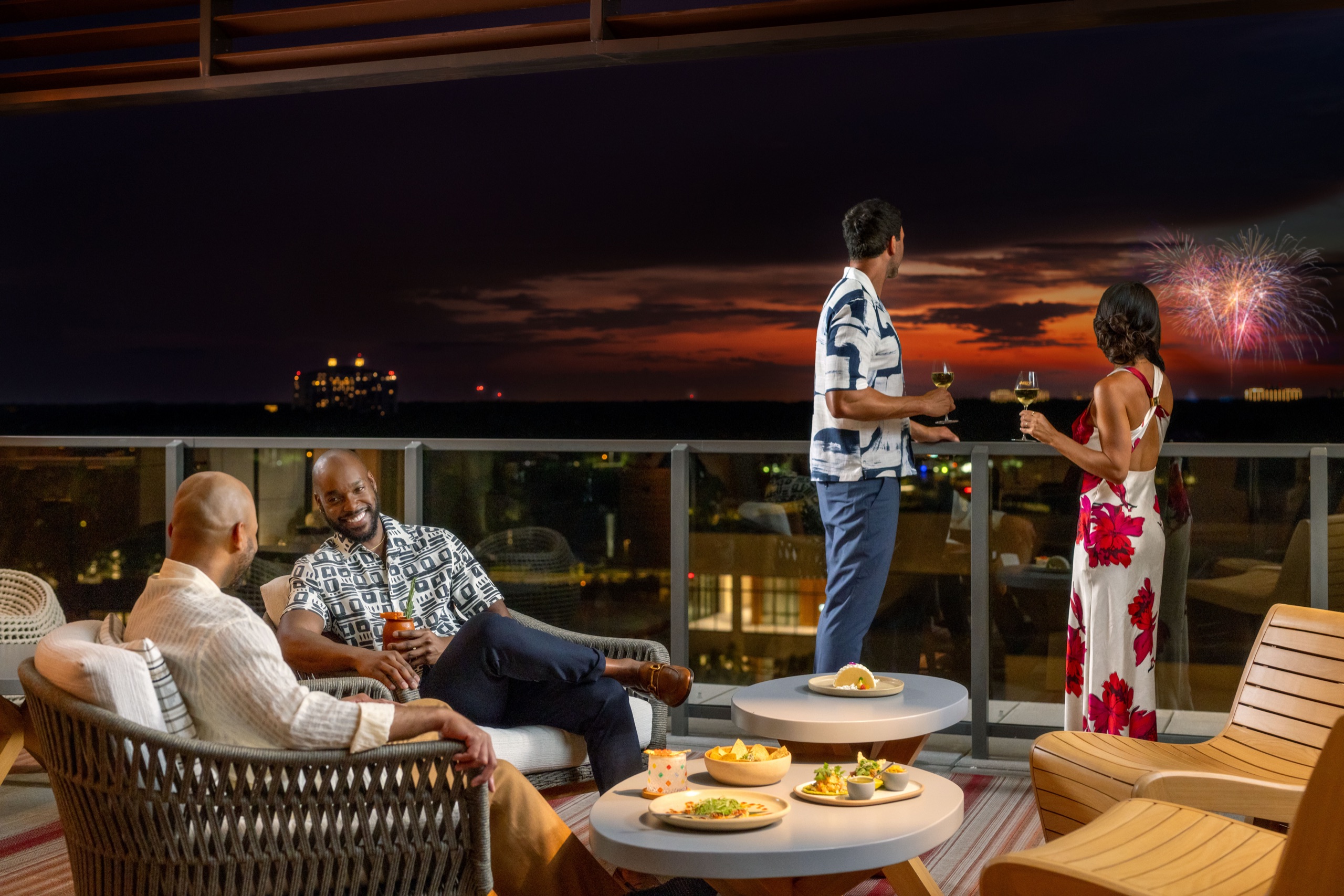 Ceiba rooftop restaurant terrace at night - guests dining with theme-park fireworks on the horizon
