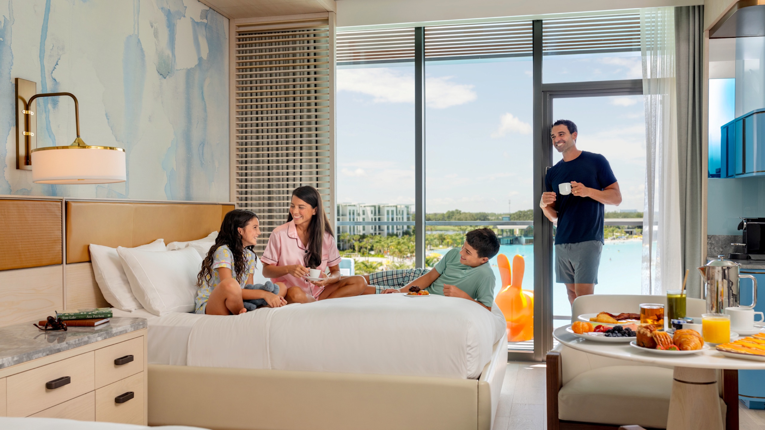 Lagoon-view guest room lifestyle - family breakfast in bed, balcony over the bay