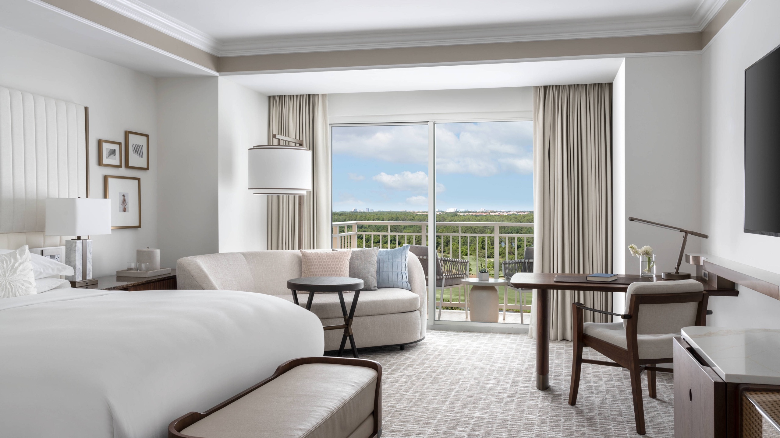 King guest room with sofa, desk and balcony over the golf course