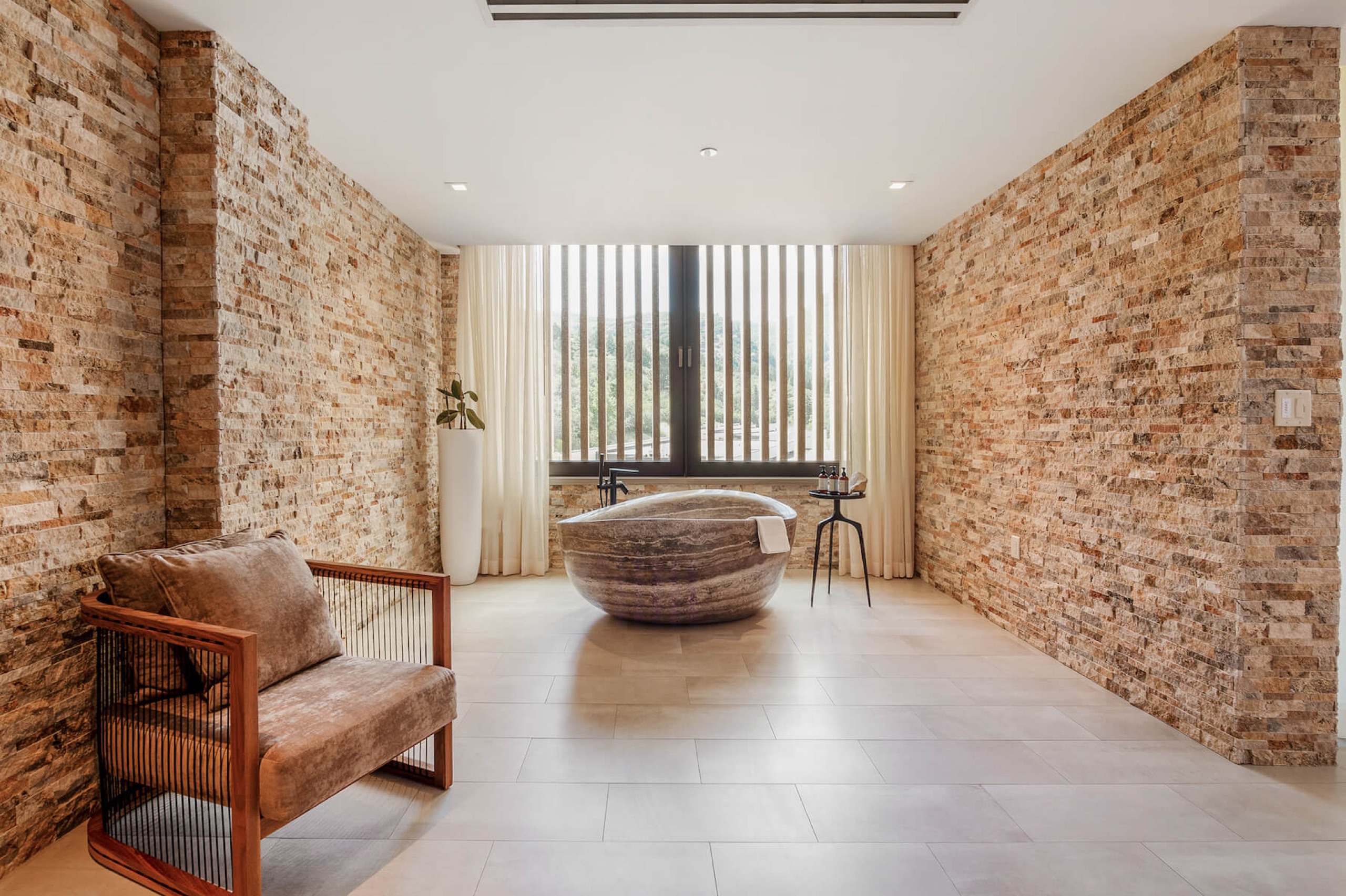 Earth Suite Deluxe - bedroom with stone walls opening to the meadow