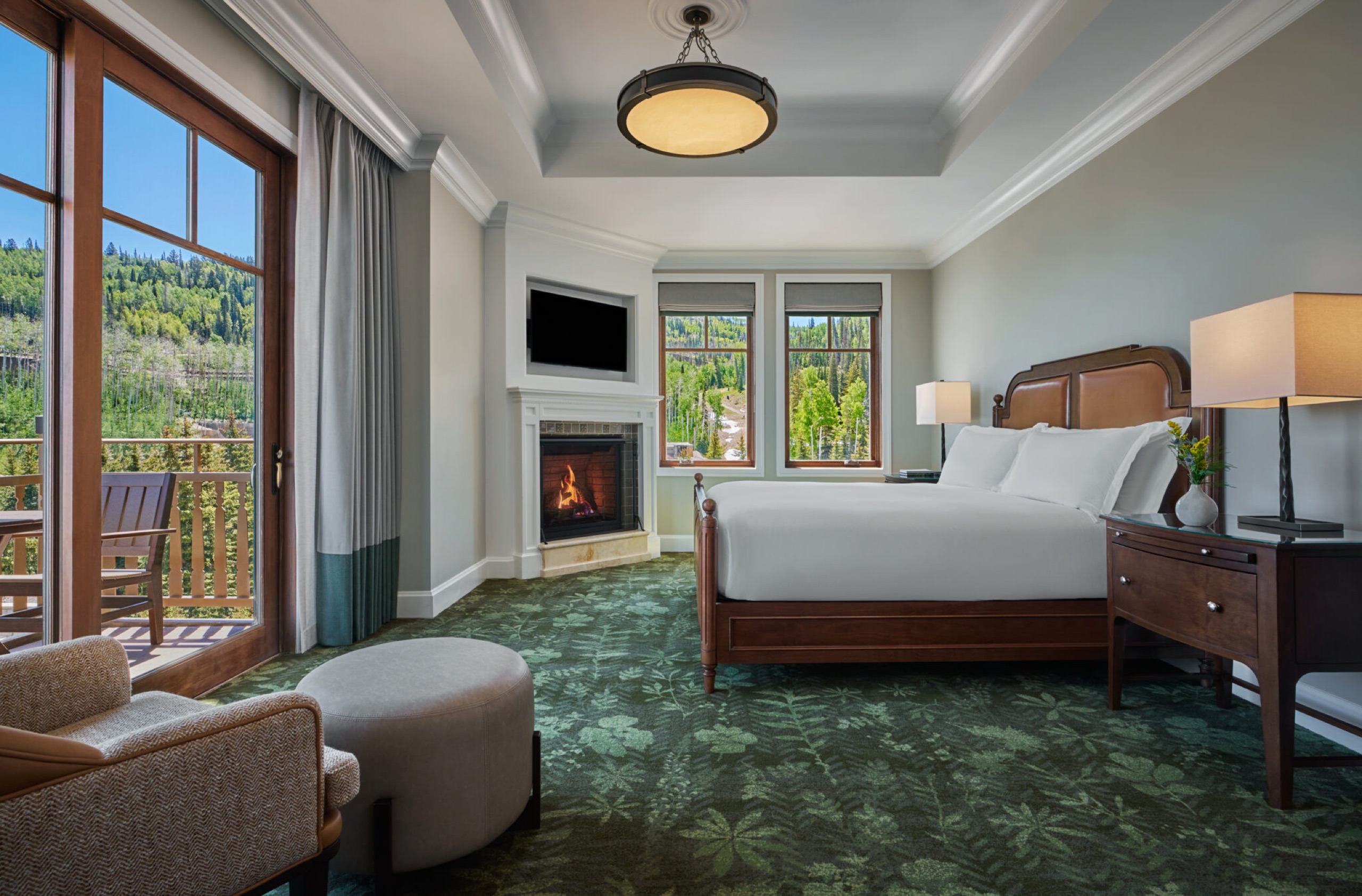 One Bedroom Suite (Peak View Suite, 1,200 sq ft) — bedroom with fireplace and slope-view balcony