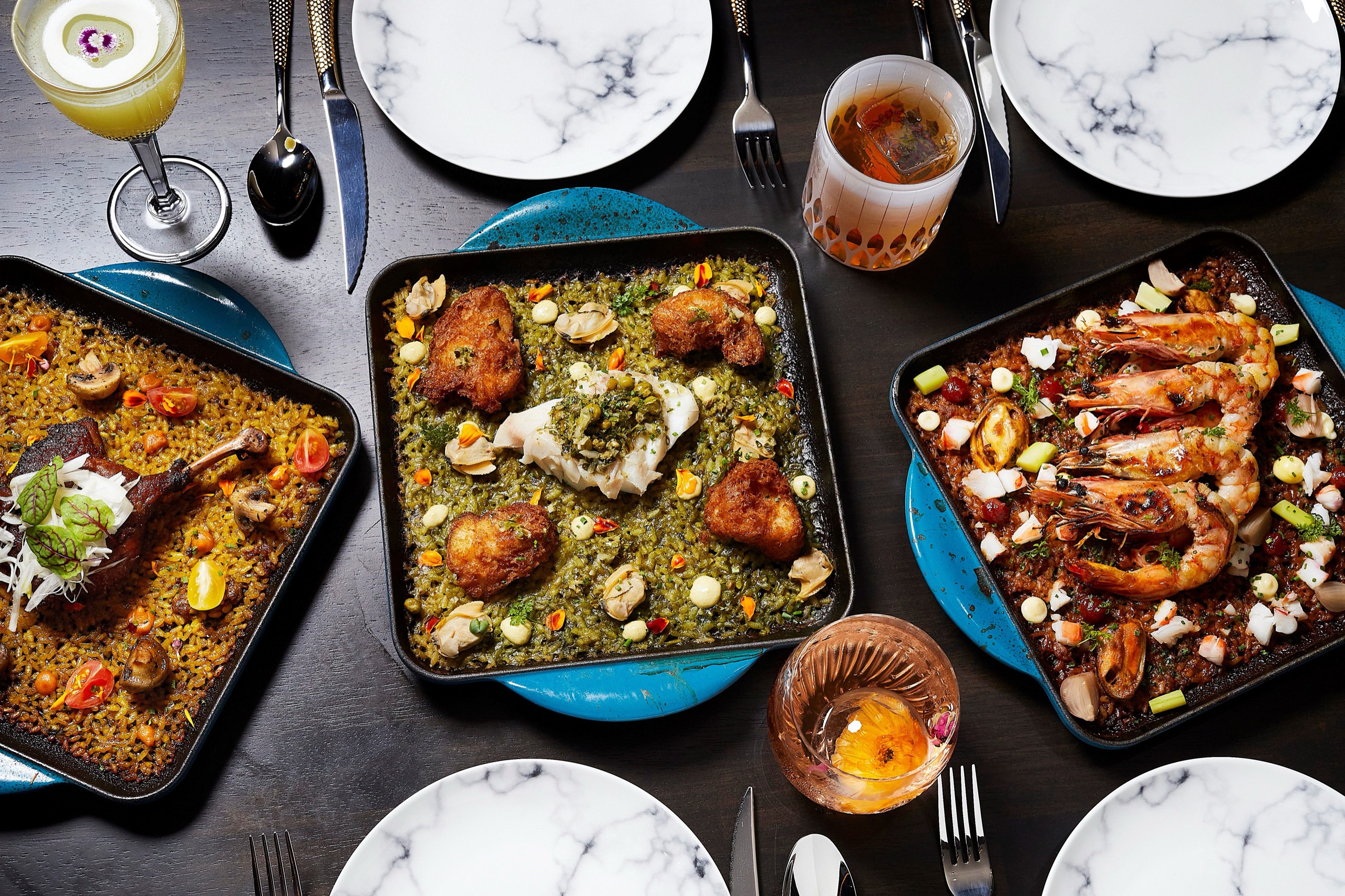 The Saga — Spanish-Latin dinner spread (paella, seafood, cocktails)